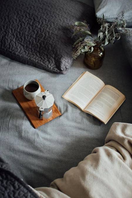 Cozy morning coffee and book on the bed, a moment for reading and unwinding